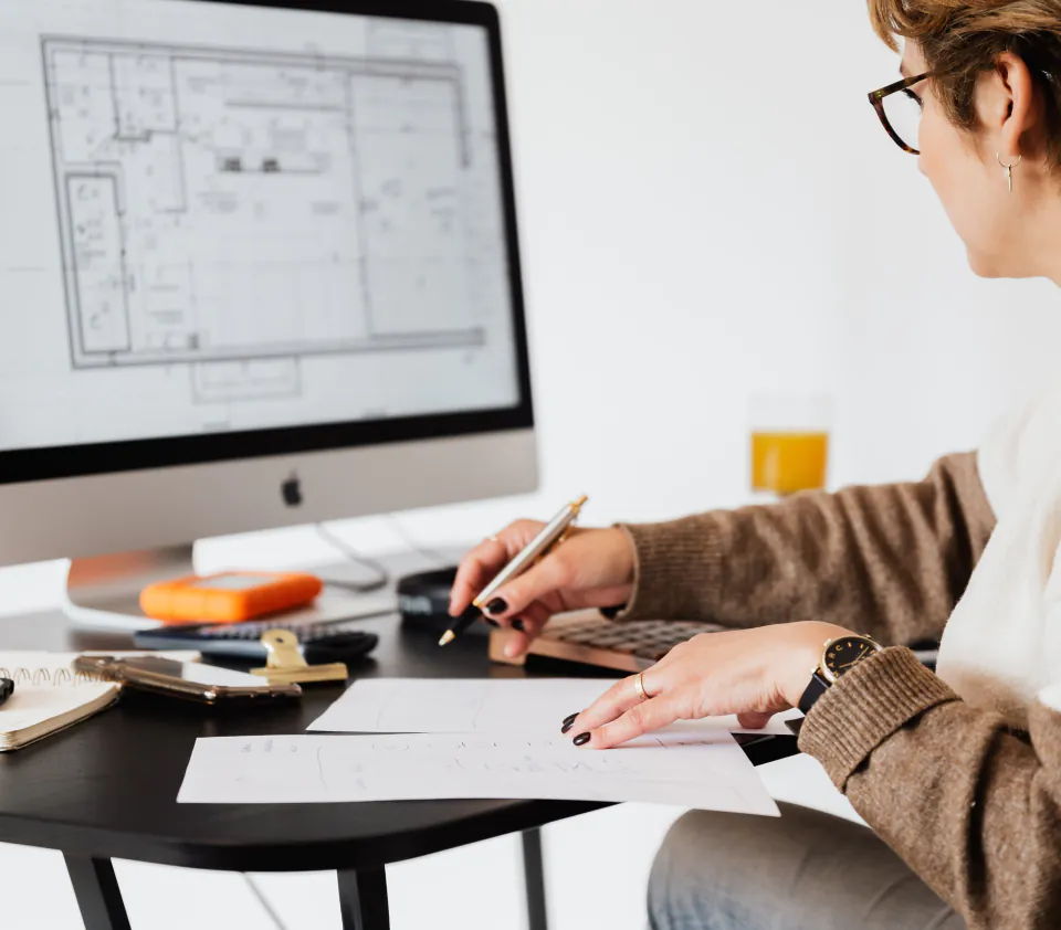 une femme assise à un bureau travaillant sur un ordinateur
